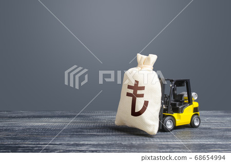 Forklift transports a turkish lira money bag. Attraction of large investments in business and economy, cheap loans, leasing. Borrowing on capital market. Stimulating economy. Crisis recovery measures Forklift transports a turkish lira money bag. Attraction of large investments in business and economy, cheap loans, leasing. Borrowing on capital market. Stimulating economy. Crisis recovery measures 68654994