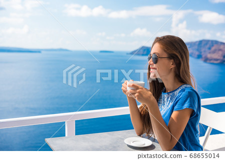 Happy Asian woman drinking coffee enjoying summer vacation at luxury hotel cafe with amazing landscape view of Oia, Santorini. Europe travel destination. Tourist lifestyle 68655014