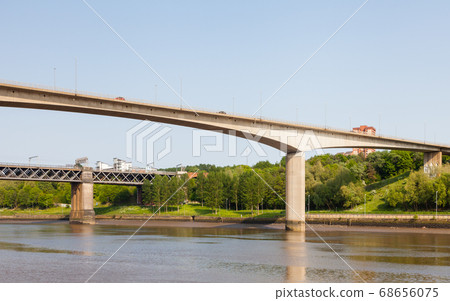Traffic is seen crossing Redheugh Bridge over the River Tyne and in the background is the King Edward VII railway bridge. The bridges connect Newcastle upon Tyne and Gateshead. 68656075