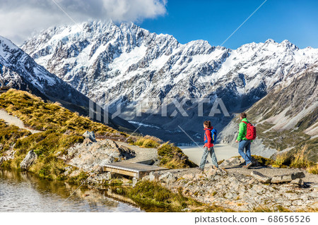 Hiking travel nature hikers in New Zealand mountains. Couple people walking on Sealy Tarns hike trail route with Mount Cook landscape, famous tourist attraction Hiking travel nature hikers in New Zealand mountains. Couple people walking on Sealy Tarns hike trail route with Mount Cook landscape, famous tourist attraction 68656526