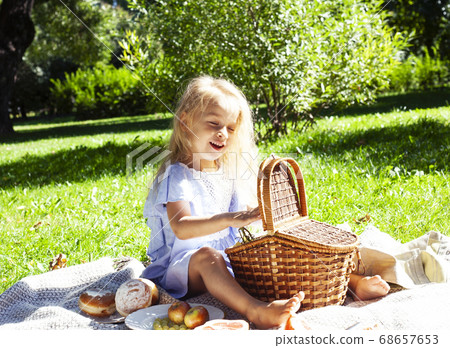 little cute blond girl outside having fun on picnic, lifestyle people concept 68657653