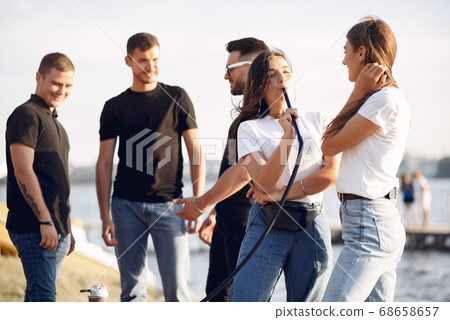 Young people eating pizza smoking hookah outside 68658657