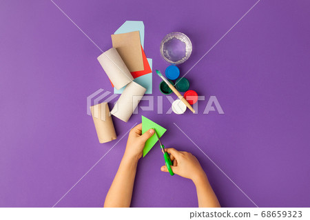 Boy makes Halloween toys from paper. toilet roll 68659323