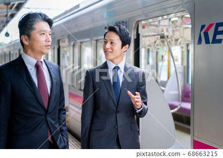 商人在車站平台“京王電鐵株式會社”交談 商人在車站平台“京王電鐵株式會社”交談 68663215