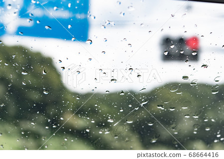 Raindrop attached to the windshield of the car Raindrop attached to the windshield of the car 68664416