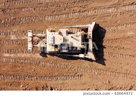 Bulldozer pushing large amount of fresh soil, Aerial shot. Bulldozer pushing large amount of fresh soil, Aerial shot. 68664972