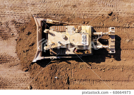 Bulldozer pushing large amount of fresh soil, Aerial shot. Bulldozer pushing large amount of fresh soil, Aerial shot. 68664973