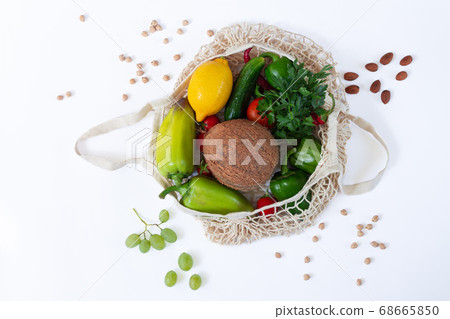 Mesh shopping grocery bag full of healthy food on white background top view Mesh shopping grocery bag full of healthy food on white background top view 68665850