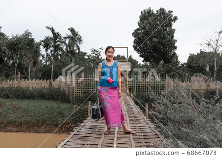 Beautiful Thai woman wearing old Thai traditional cloth standing on bamboo bridge. Beautiful Thai woman wearing old Thai traditional cloth standing on bamboo bridge. 68667073