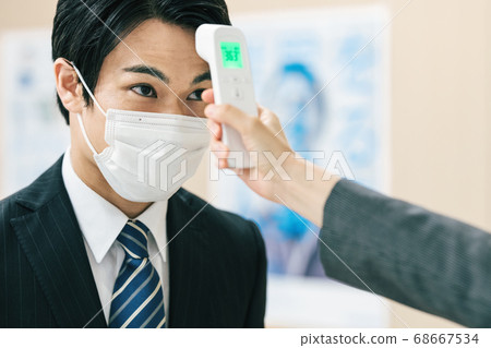 Temperature measurement scene of a man wearing a suit 68667534