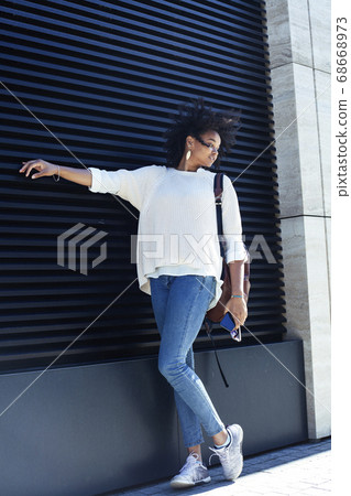 young pretty african girl posing cheerful on city background, lifestyle outdoor people concept 68668973