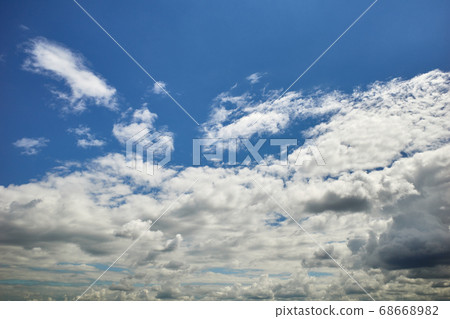 Cumulus-strewn blue sky in sun light Cumulus-strewn blue sky in sun light 68668982
