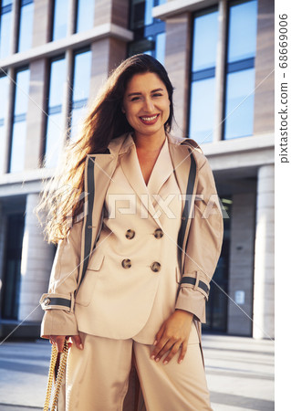 young pretty brunette woman in fashion suit at business building posing cheerful, lifestyle people concept 68669006
