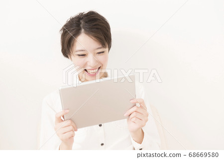 A woman watching a tablet PC 68669580