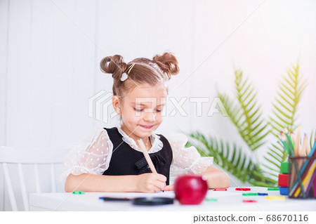 Happy smiling pupil at the desk. Girl in the class room with pencils, books. Kid girl from primary school. first day of fall. Back to school 68670116
