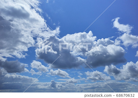 Cloudy blue sky lightened by bright midday sun Cloudy blue sky lightened by bright midday sun 68670632
