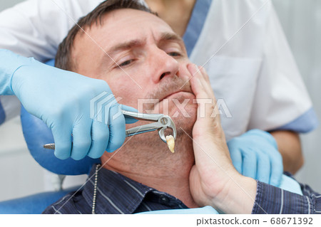Dentist has extracted a sick tooth from patient in 68671392