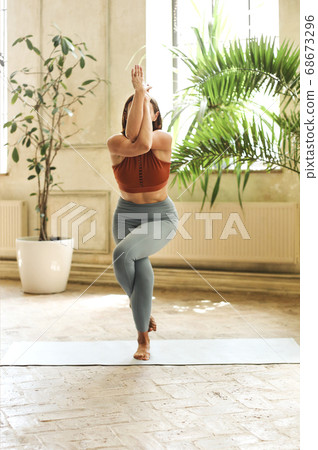 Slim woman doing yoga at home 68673296