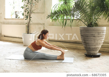 Slim woman doing yoga at home 68673305