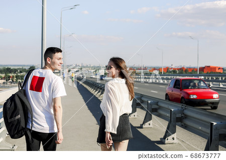 Happy couple walking along bridge 68673777
