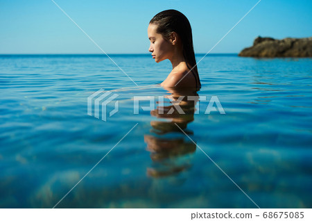 Beautiful brunette woman on the beach 68675085