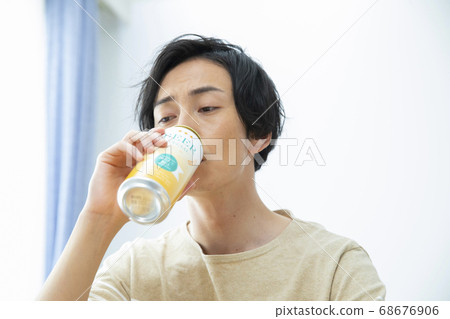 Man drinking beer alone in the room 68676906