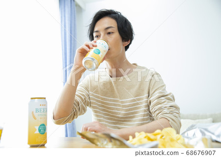 Man drinking beer alone in the room 68676907