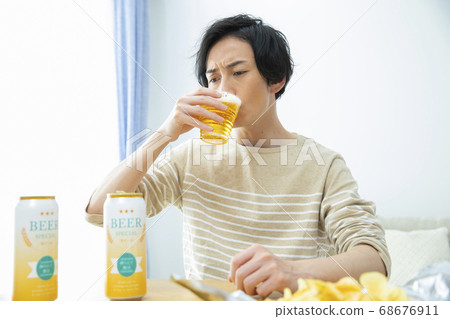 Man drinking beer alone in the room 68676911