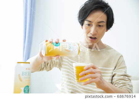 Man drinking beer alone in the room 68676914