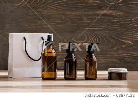 Cosmetic dark amber bottles on wooden  table 68677128