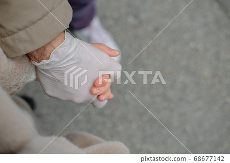 Two hands of a couple one in a plastic glove virus 68677142