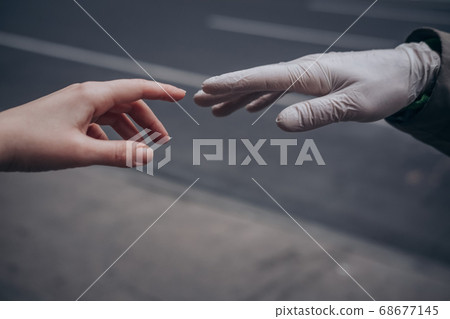 Two hands of a couple one in a plastic glove virus 68677145