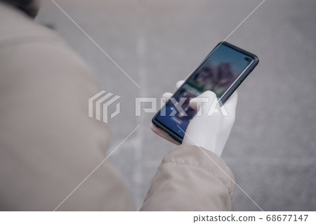 Man holding phone in a rubber glove virus 68677147