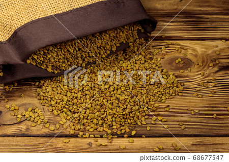 Fenugreek seeds on wooden table 68677547