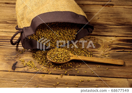 Fenugreek seeds on wooden table 68677549