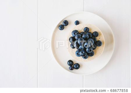 Vegan vanilla blueberry cheesecake on white background. Vegan vanilla blueberry cheesecake on white background. 68677858