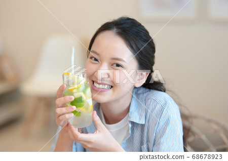 Woman enjoying lemonade at home 68678923