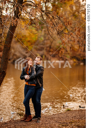 man and woman flirt in autumn park near river. man and woman flirt in autumn park near river. 68679570