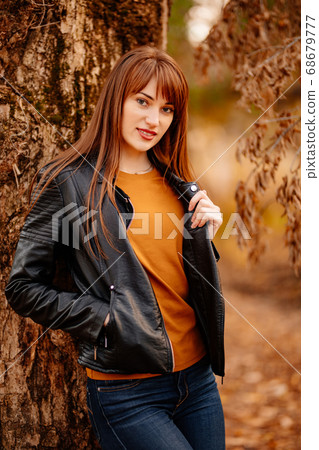 beautiful woman near tree in autumn Park. 68679777