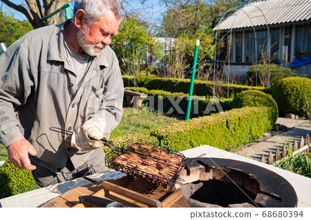 man. meat is cooked inside aboveground tandir oven man. meat is cooked inside aboveground tandir oven 68680394