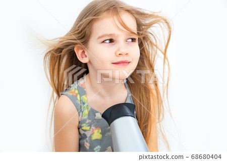 little girl drying her long hair with hair dryer little girl drying her long hair with hair dryer 68680404