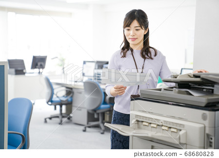Female employee making a copy Female employee making a copy 68680828