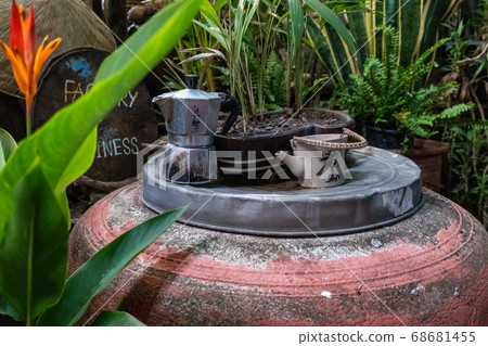 A small ceramic kettle and Moka Pot with a plant in a pot 68681455