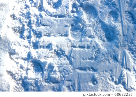 Blue white snow background with traces of people and cars 68682255