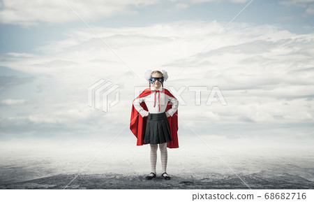 Girl power concept with cute kid guardian against cloudscape background . Mixed media Girl power concept with cute kid guardian against cloudscape background . Mixed media 68682716