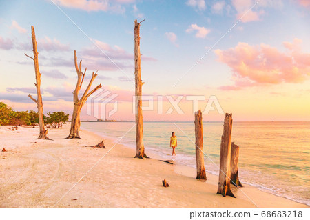 Lovers key beach in the gulf of Mexico, Florida travel destination. Woman relaxing watching sunset walking in ocean water on american beach. Southwest Florida Lovers key beach in the gulf of Mexico, Florida travel destination. Woman relaxing watching sunset walking in ocean water on american beach. Southwest Florida 68683218