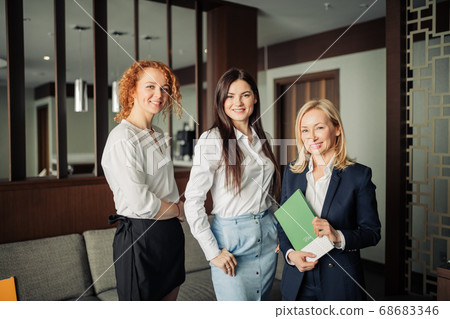 Portrait of three caucasian business women in formal wear in a hotel lobby Portrait of three caucasian business women in formal wear in a hotel lobby 68683346