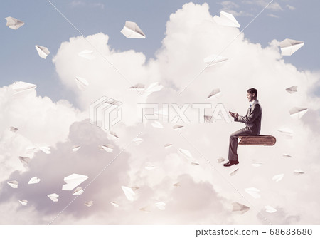 Businessman or student on book and paper planes flying around 68683680