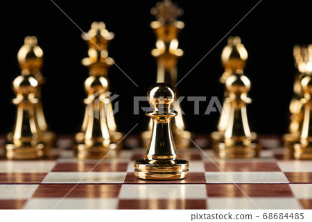 Golden chess figures standing on chessboard 68684485