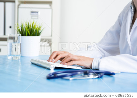 Doctor typing at computer keyboard 68685553